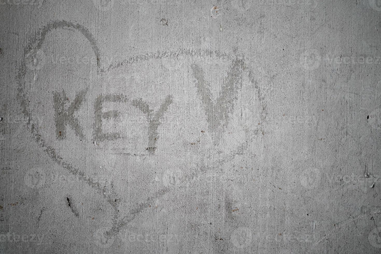 Key wording in scratching heart sign on old cement wall. photo