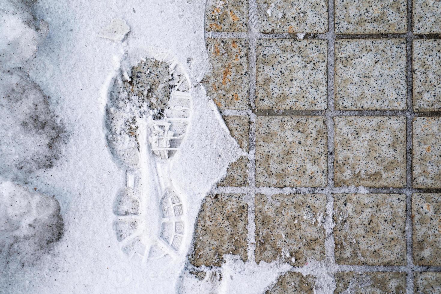 footprint in snow with half side tile in image in Japan. photo