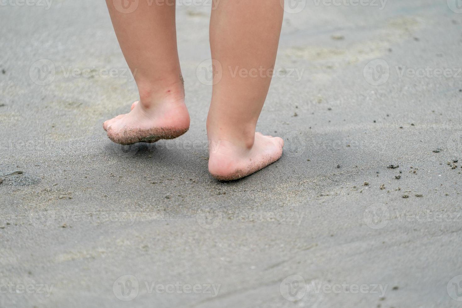close up kid's legs, play and learn at the beach. photo