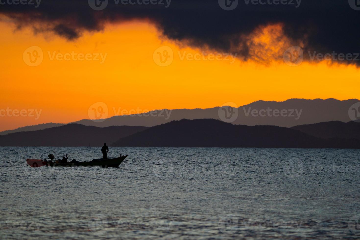 Thailand sea in twilight time with Silhouette ship and fisherman in the sea photo