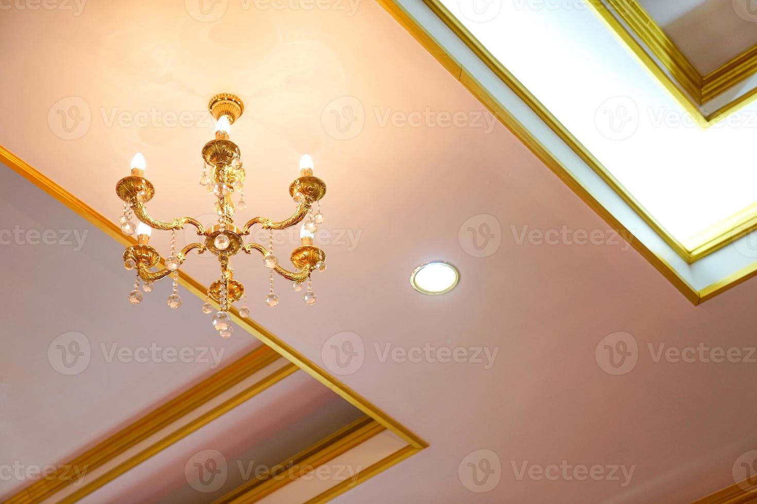 Simple and minimize chandelier gold colour on the ceiling photo
