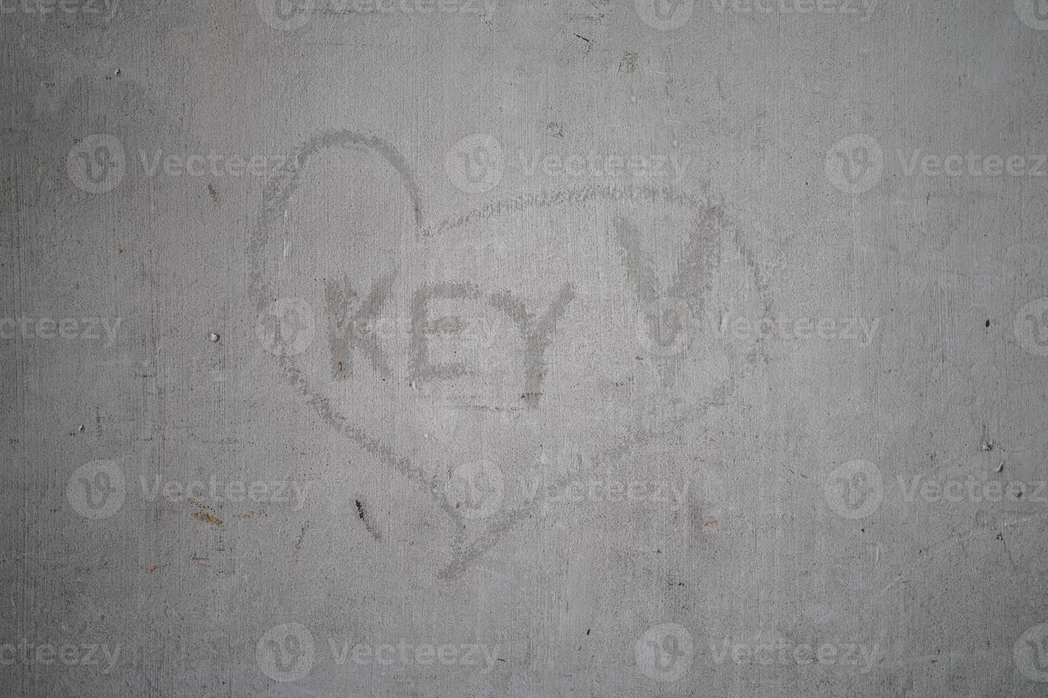Key wording in scratching heart sign on old cement wall. photo