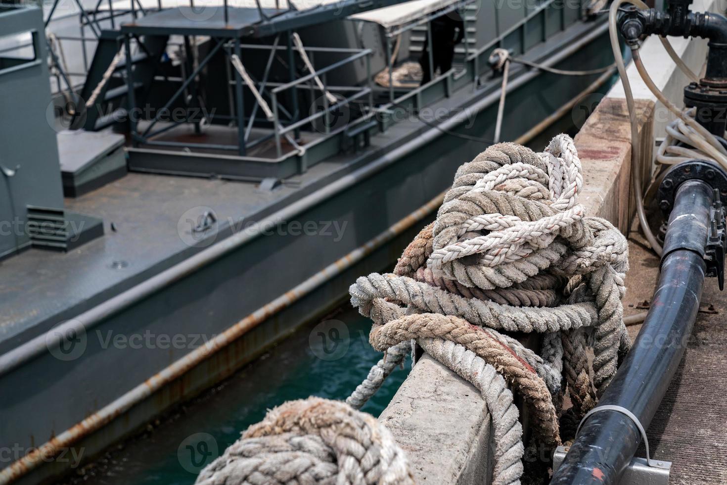 Navy's Rope on the cement floor with the war ship background. photo