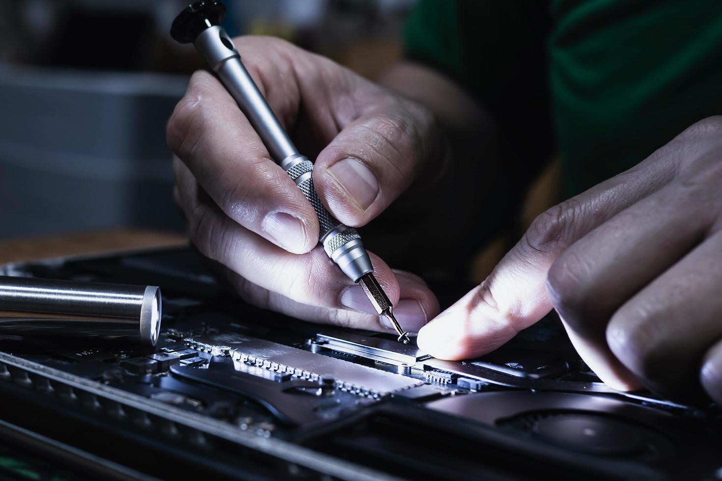 Man fixing laptop computer - technology computer reparing concept photo