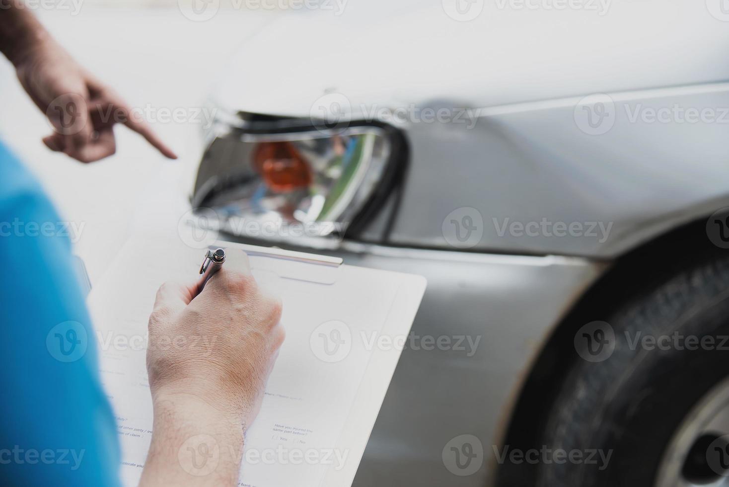 agente de seguros que trabaja durante el proceso de reclamación de accidentes de coche en el lugar - concepto de reclamación de seguros de personas y coches foto