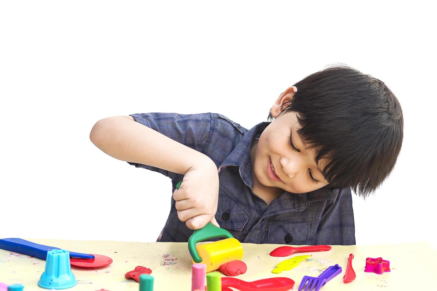 Asian lovely boy is playing clay happily over white background photo