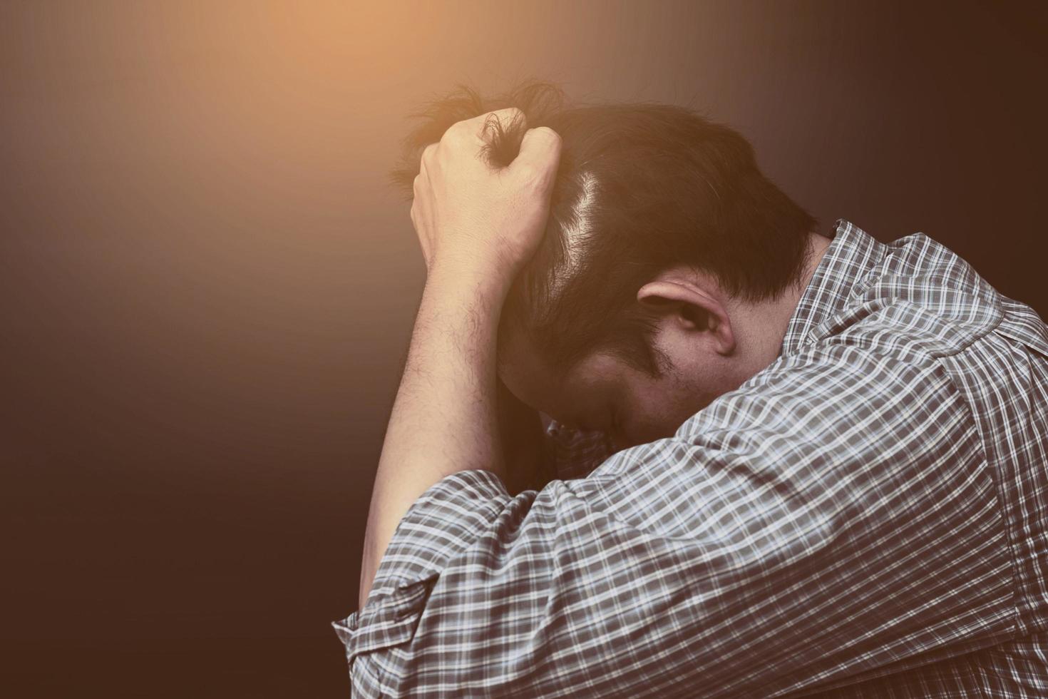 Sad man holding head with hand photo