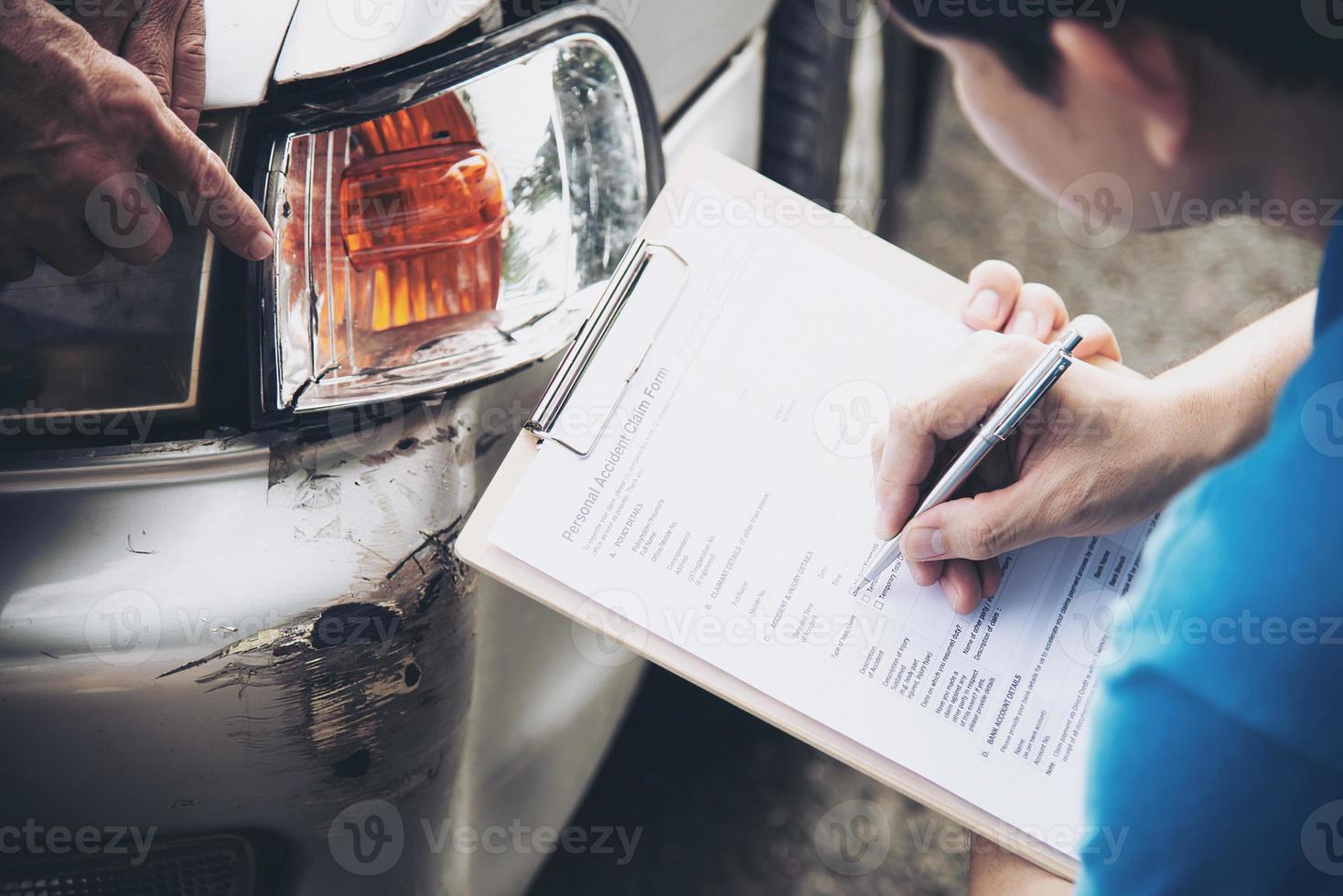 agente de seguros que trabaja durante el proceso de reclamación de accidentes de coche en el lugar - concepto de reclamación de seguros de personas y coches foto