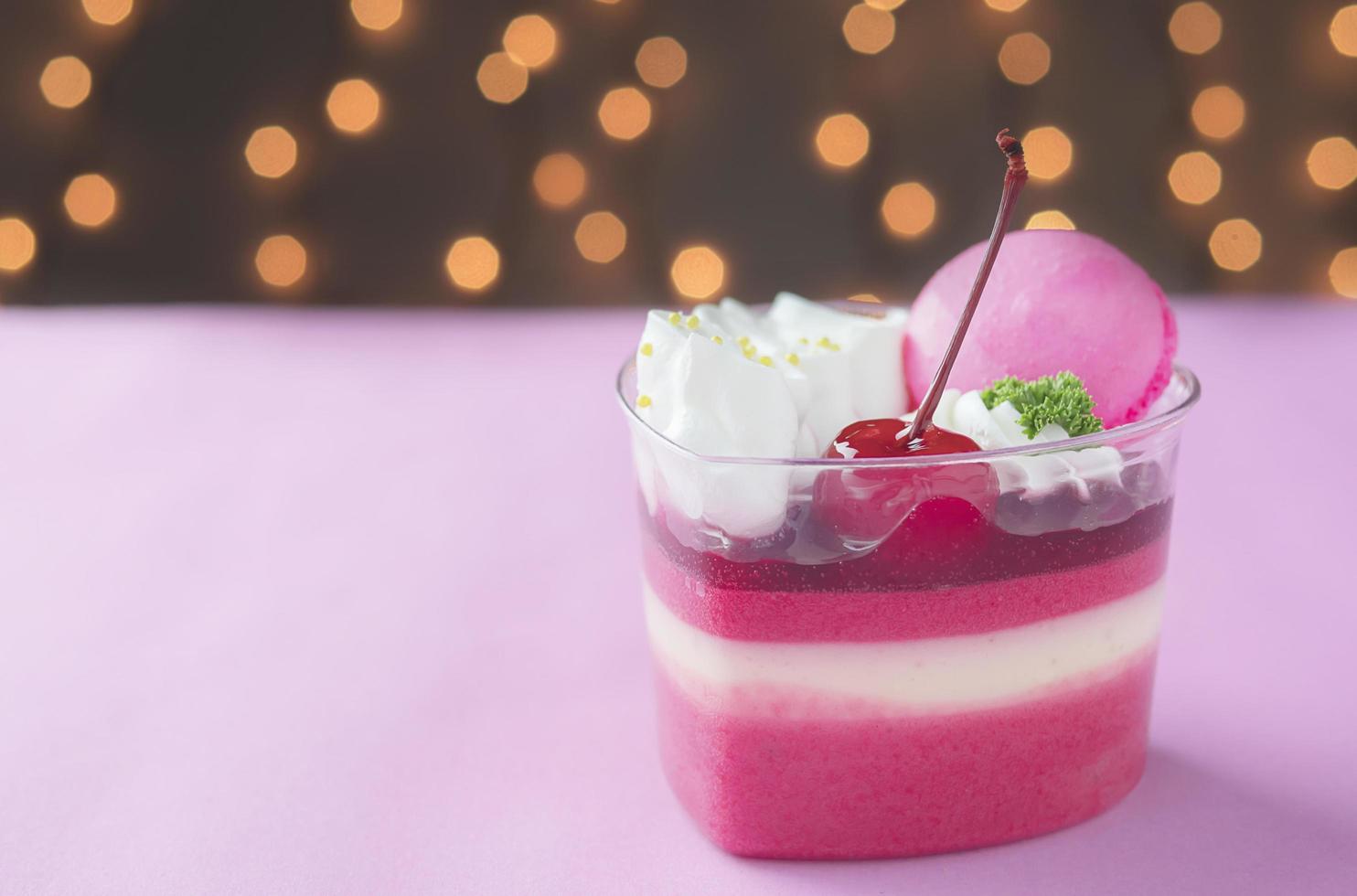 Colorful strawberry cake and macaron over shiny bokeh background photo