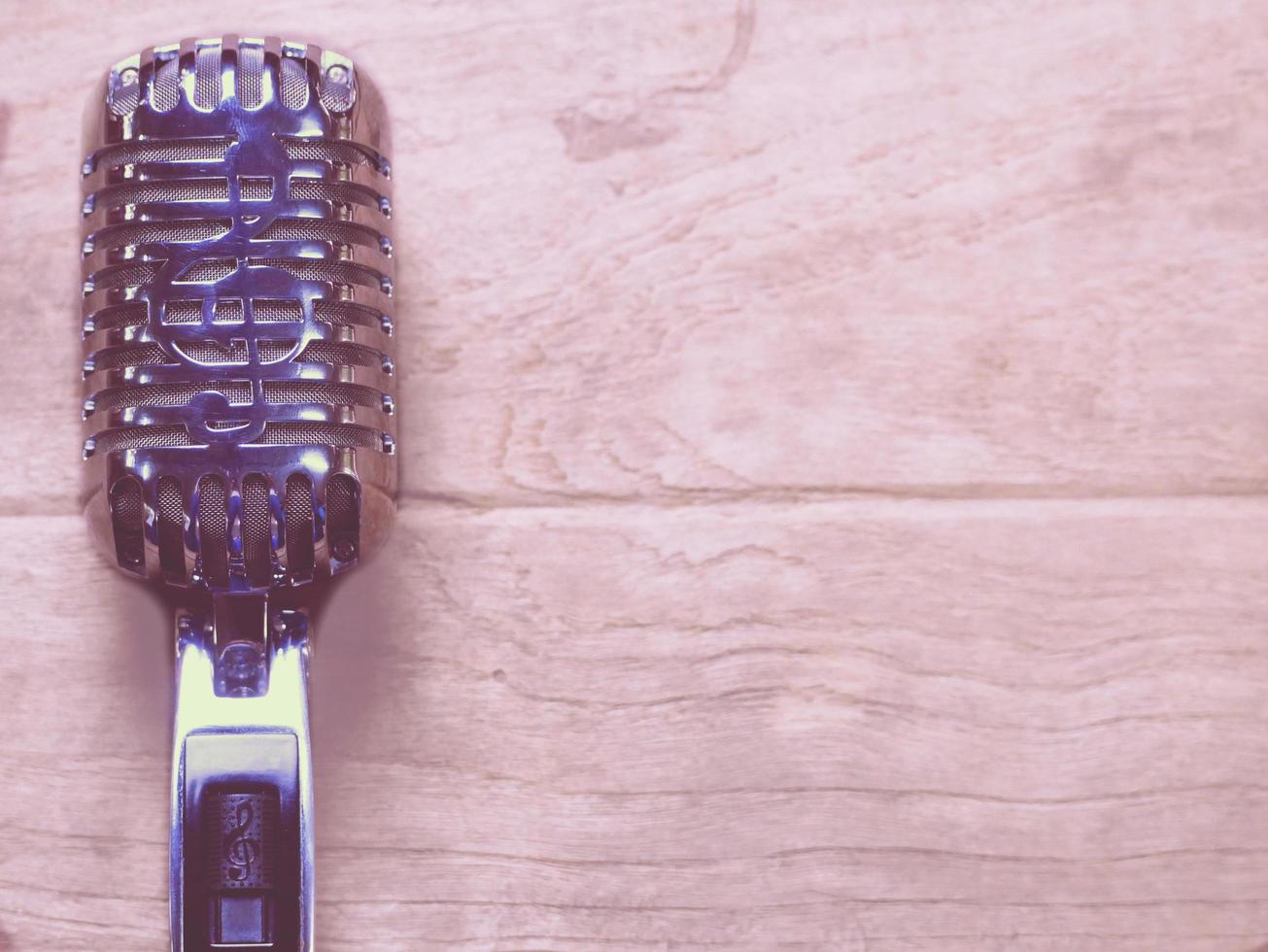 Vintage style classic microphone placed on an old wood. photo