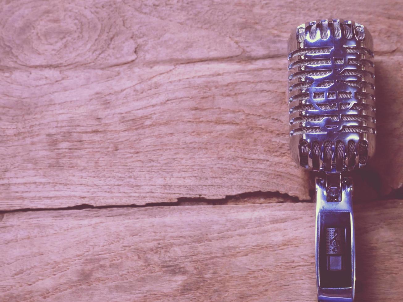 Vintage style classic microphone placed on an old wood. photo