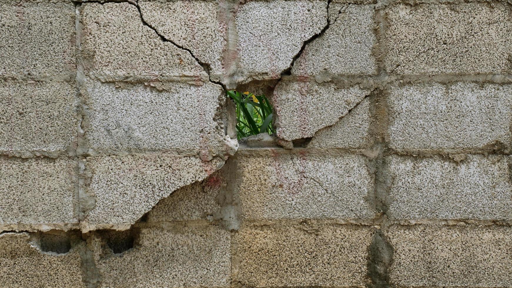 The old cement wall picture is cracked due to the impact of incomplete construction. photo