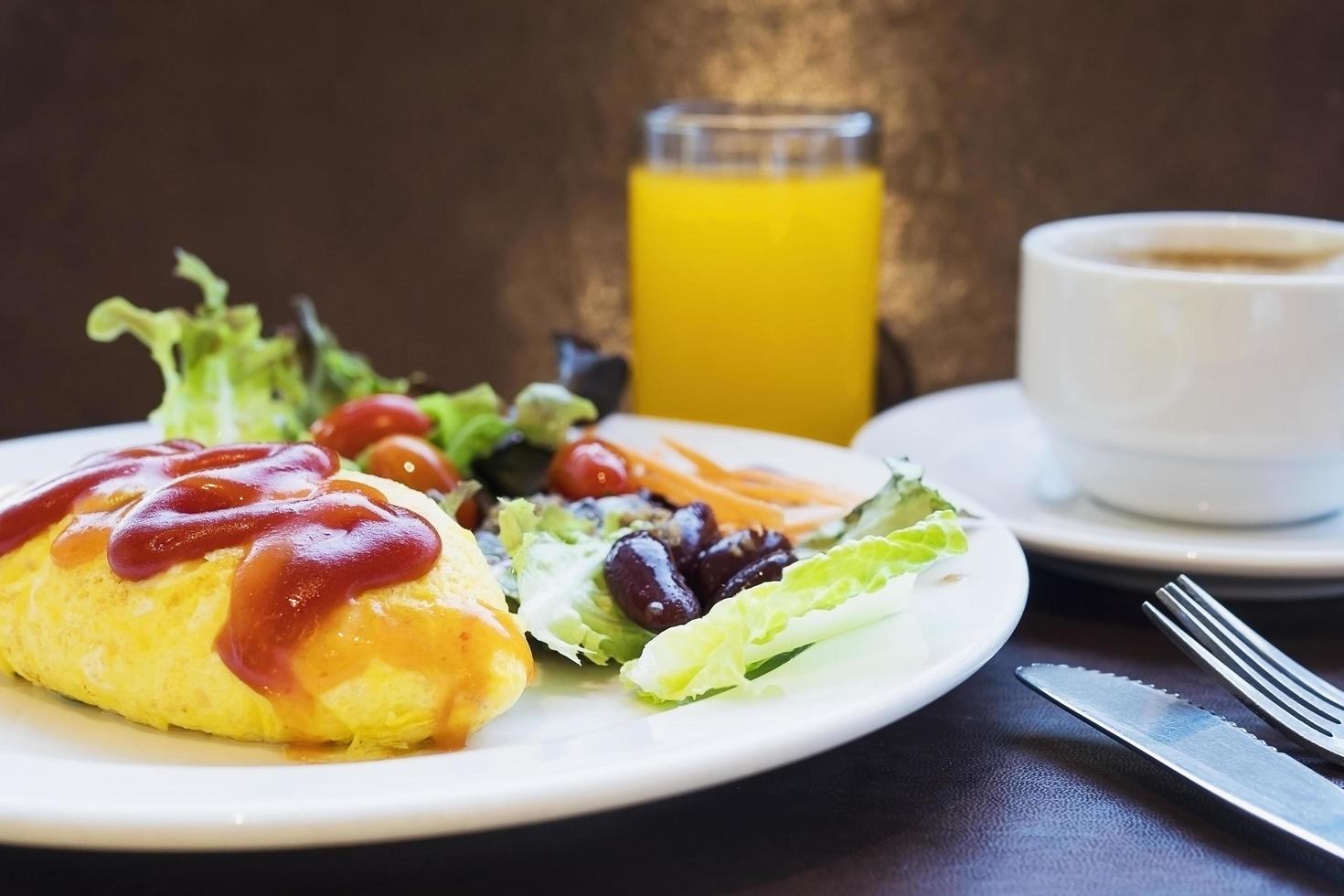 tortilla con ensalada de verduras frescas y jugo de naranja con juego de desayuno de café foto