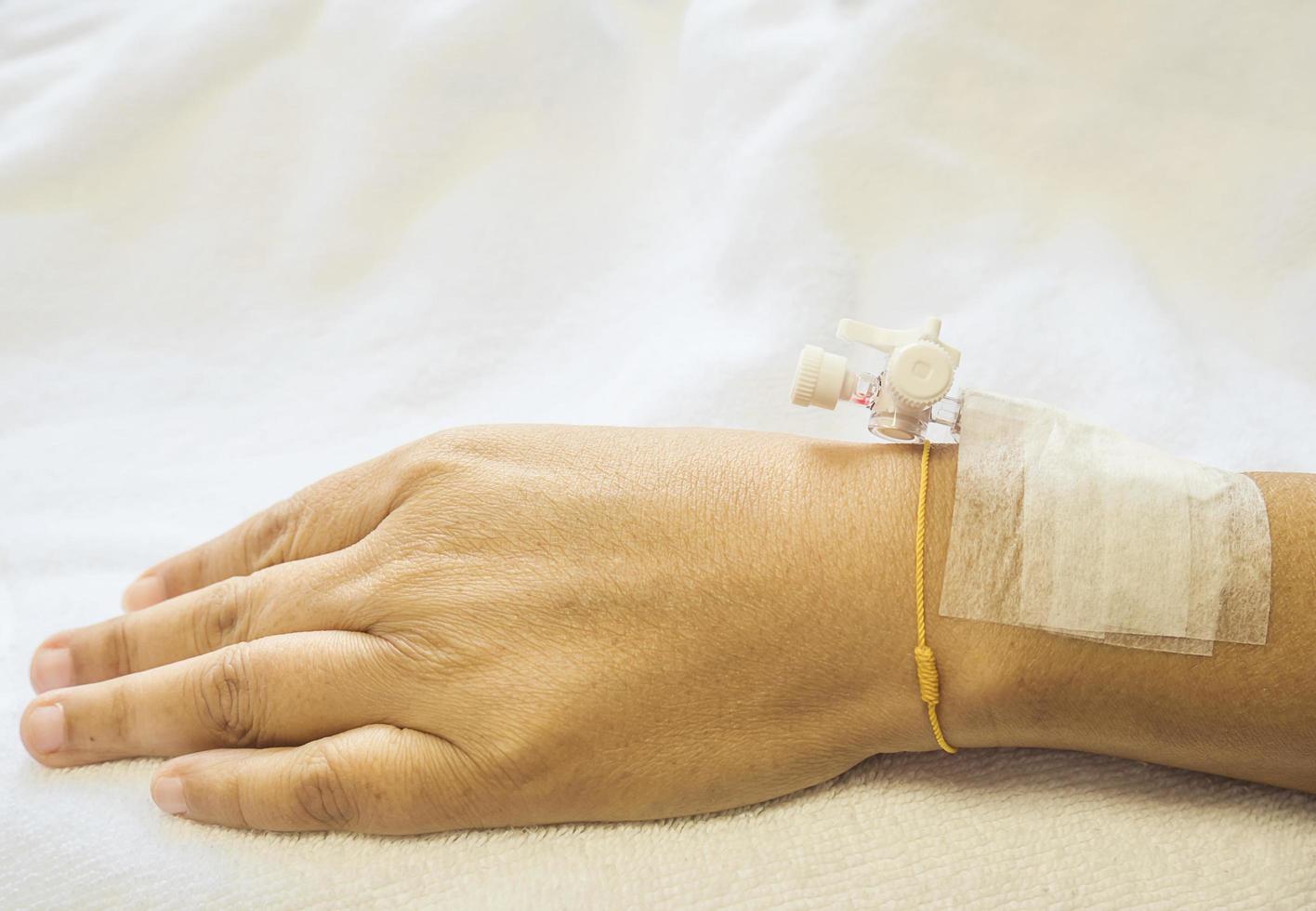 Patient's hand with medicine drip injection, lady on a bed in a hospital photo
