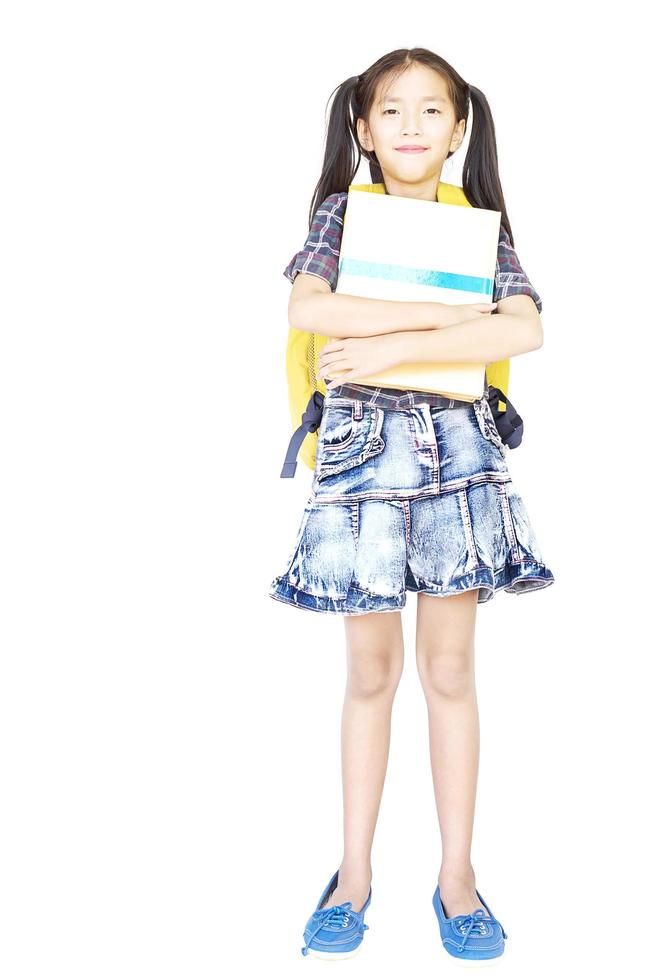 10 years old Asian schoolgirl standing and holding book isolated over white photo