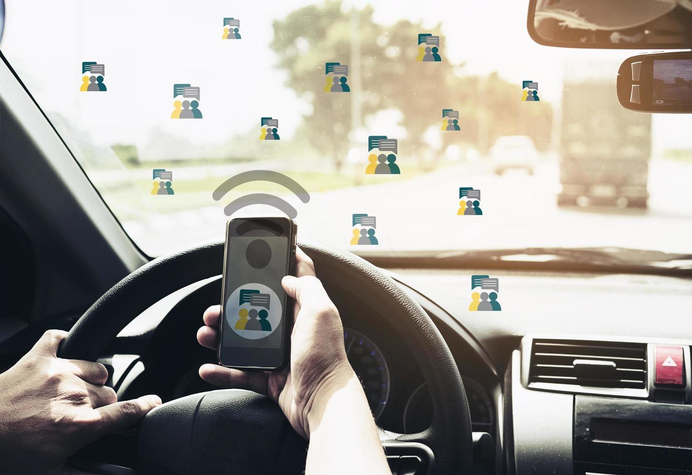 Close up of a man driving car dangerously while chating on mobile phone photo