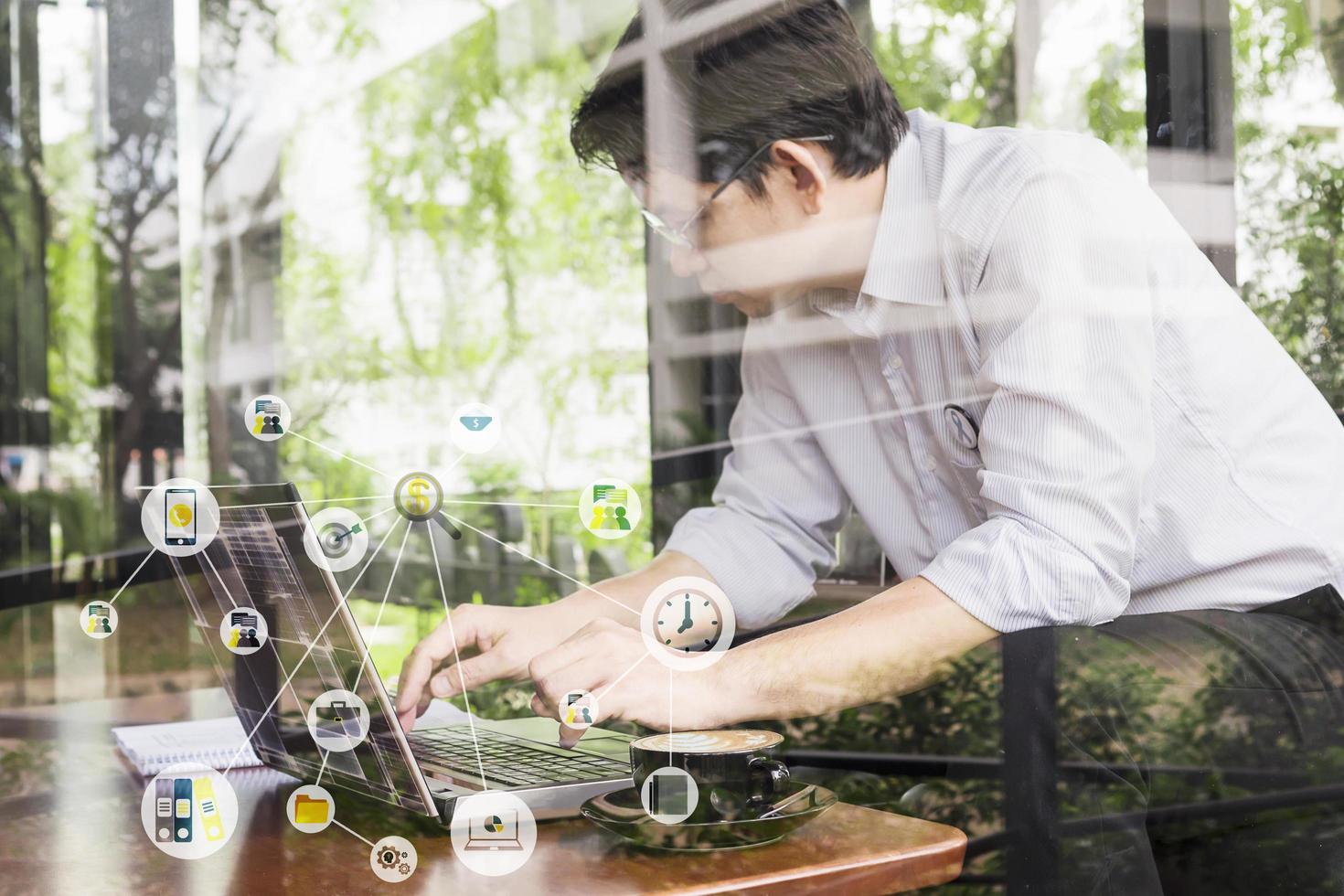 Businessman is working with his computer in coffee shop with office icons overlay, online everywhere can work concept photo