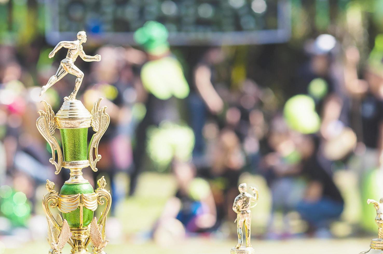 Sport trophy over blur crowded people in school sport day festival photo