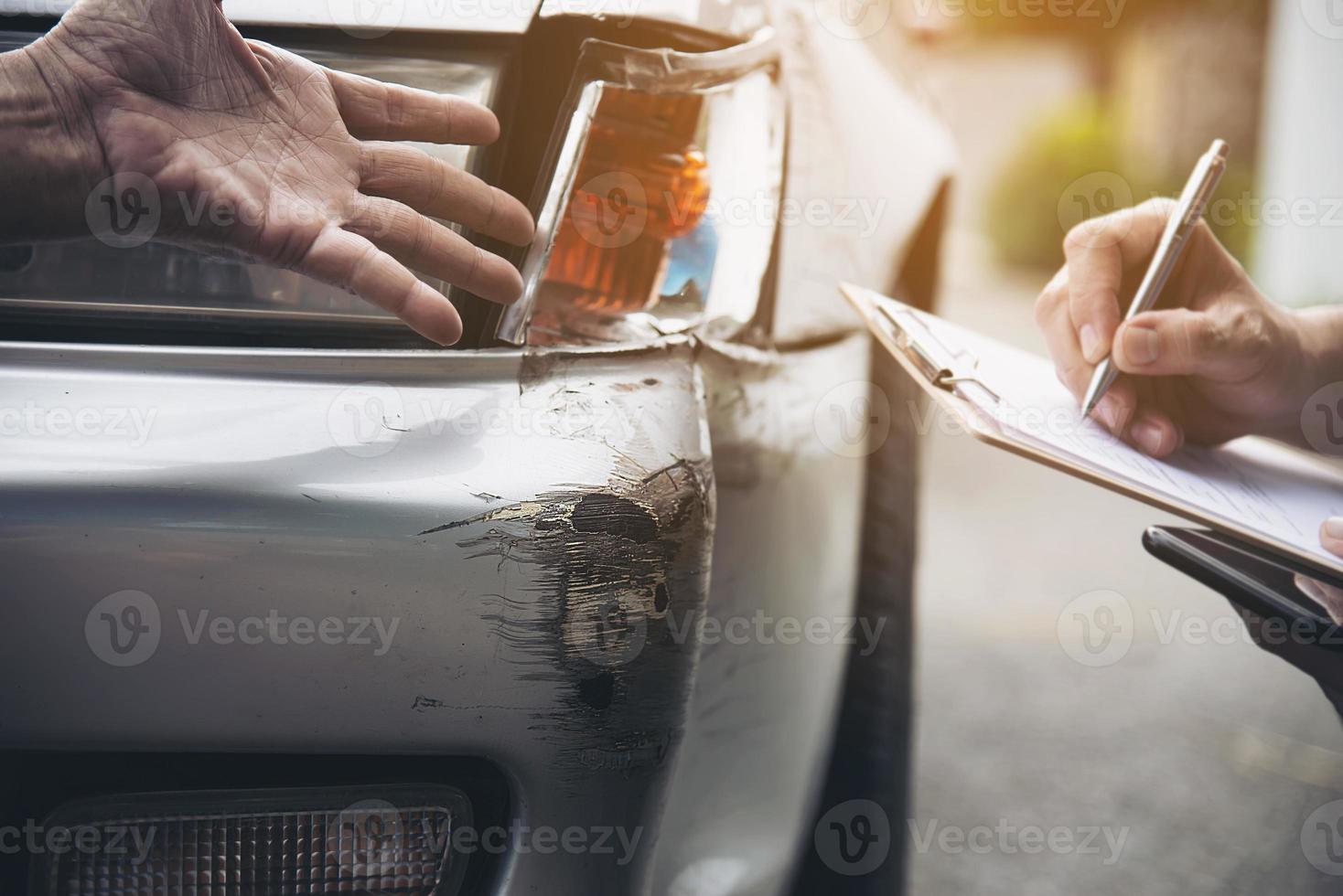 Insurance agent working during on site car accident claim process - people and car insurance claim concept photo