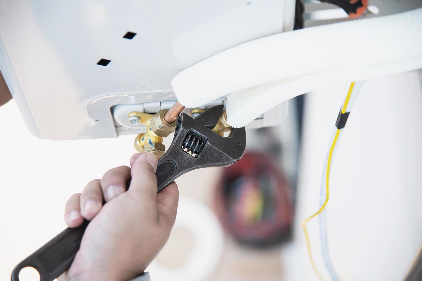 Man is installing wall compressor of air conditioner during hot season photo