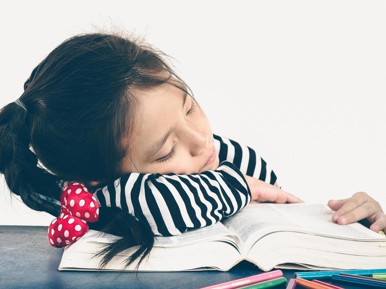 Vintage tone of Asian kid is sleeping while reading a big book. photo