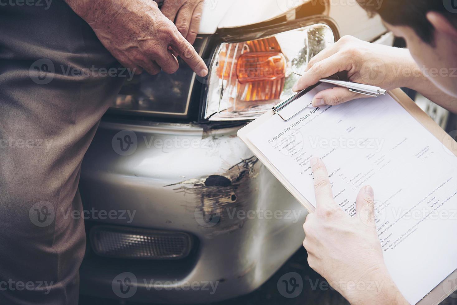 agente de seguros que trabaja durante el proceso de reclamación de accidentes de coche en el lugar - concepto de reclamación de seguros de personas y coches foto