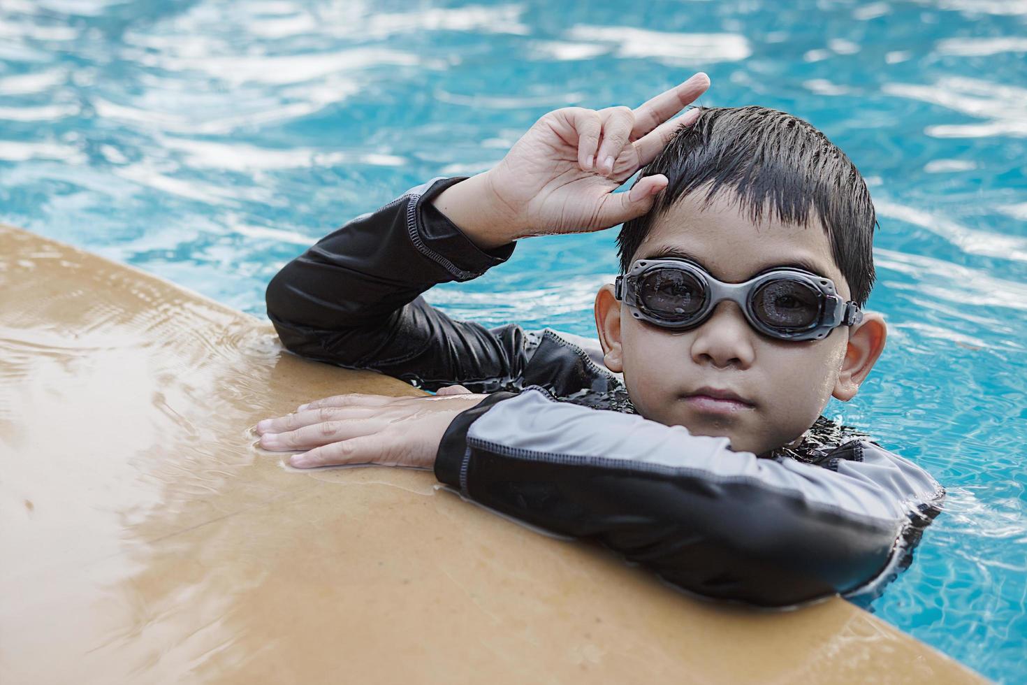 Asian happy kid playing in swimming pool photo