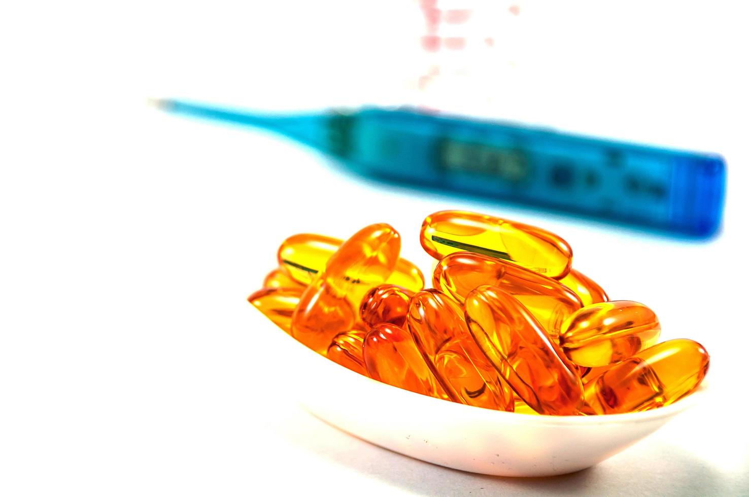 Fish oil with thermometer and glass on white background photo
