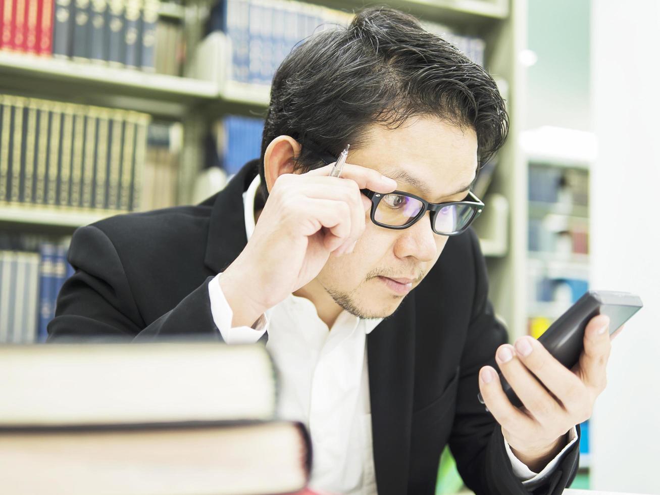 Business man is looking at his mobile phone in his office photo