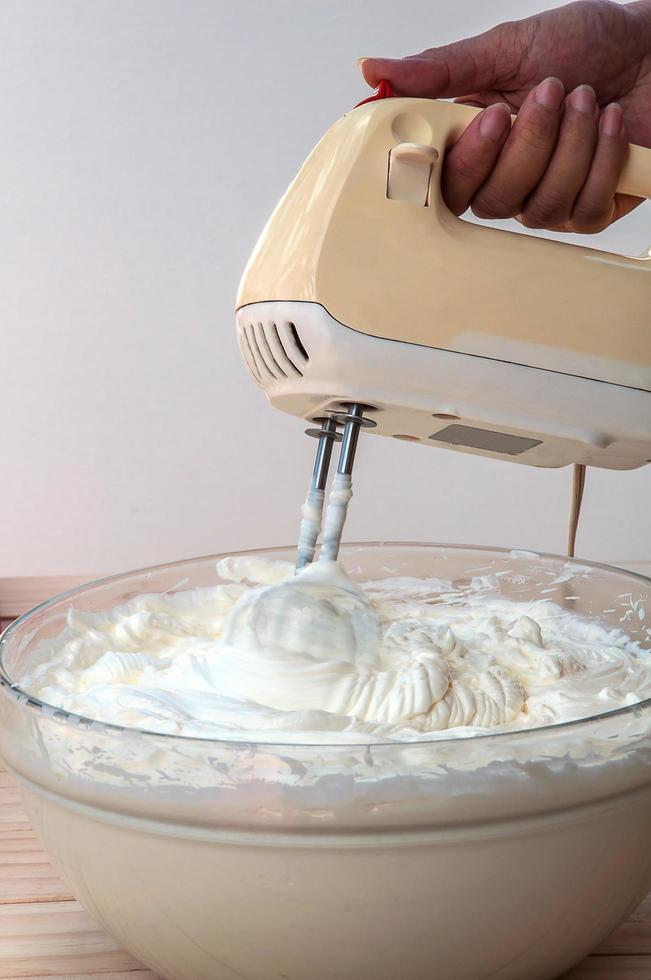 Hacer pastel de crema de mantequilla con batidora de mano foto