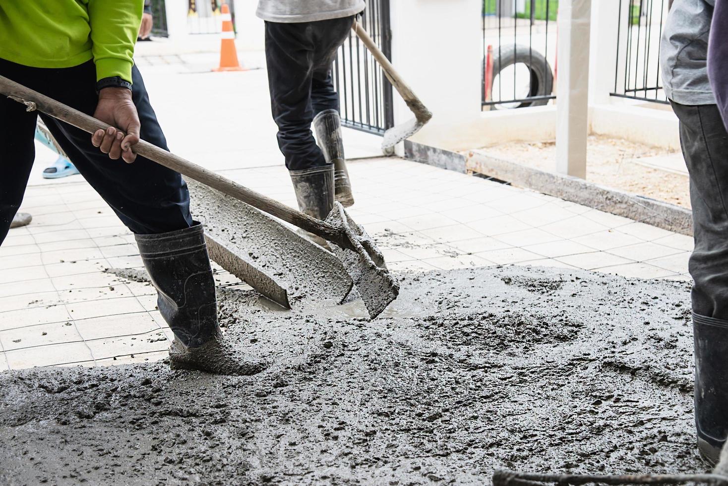 Workman doing floor concrete pouring job in construction site photo