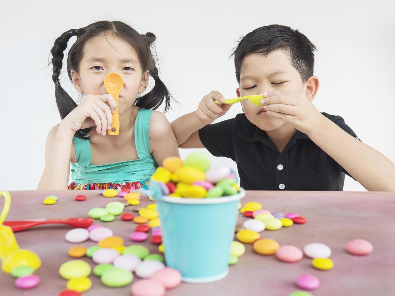 Asian kids are playing with candy. Photo is focused at kids face.