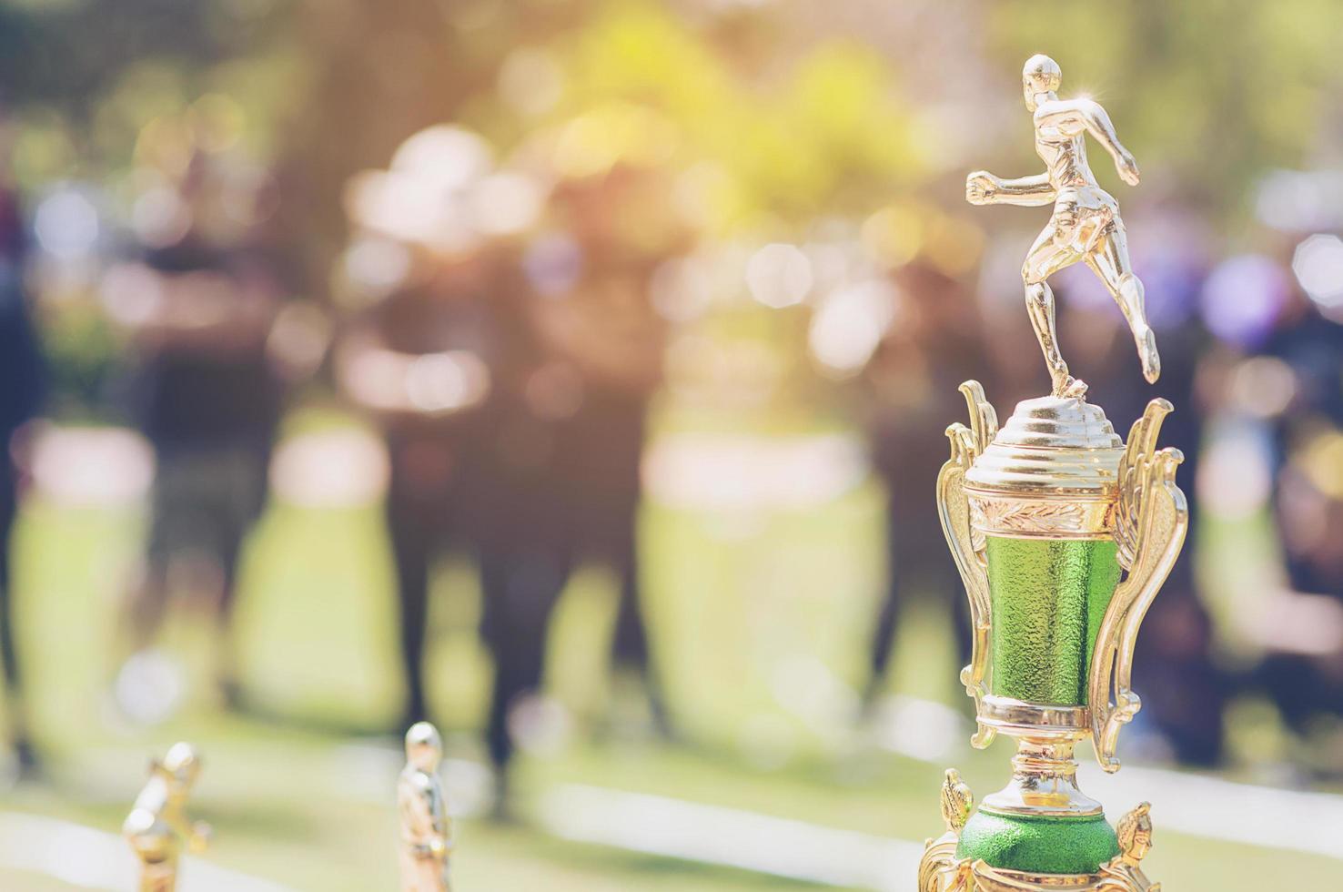 trofeo deportivo sobre desenfoque de gente abarrotada en el festival del día del deporte escolar foto