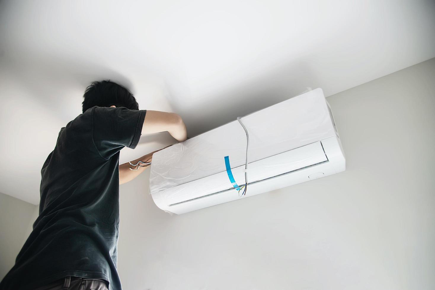 Technician is installing air conditioner during hot season photo