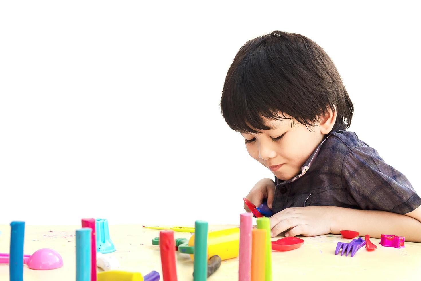 Asian lovely boy is playing clay happily over white background photo
