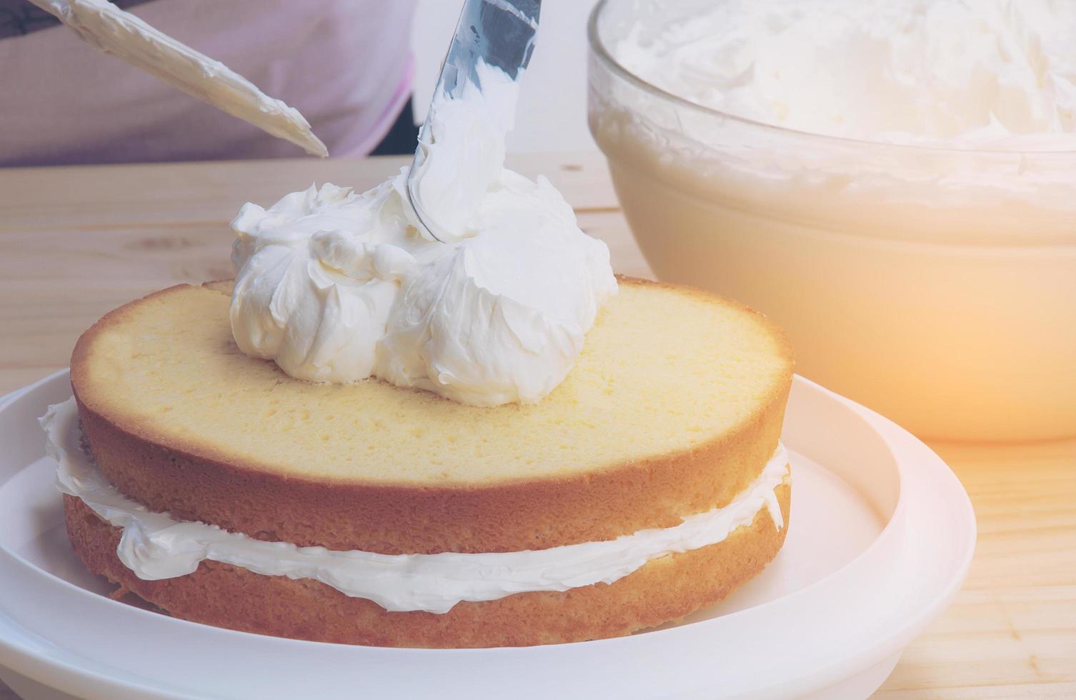 Vintage photo of putting butter  cream cake by hand using spatula