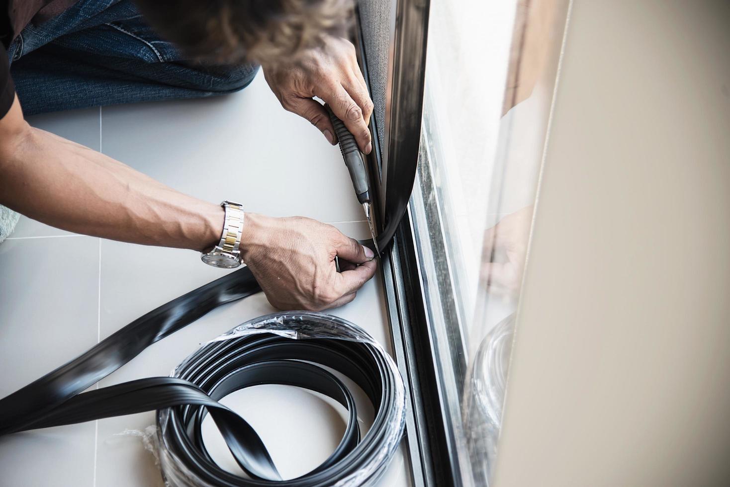 Man doing aluminum frame with glasses and wire screen door and window installation work in construction site photo