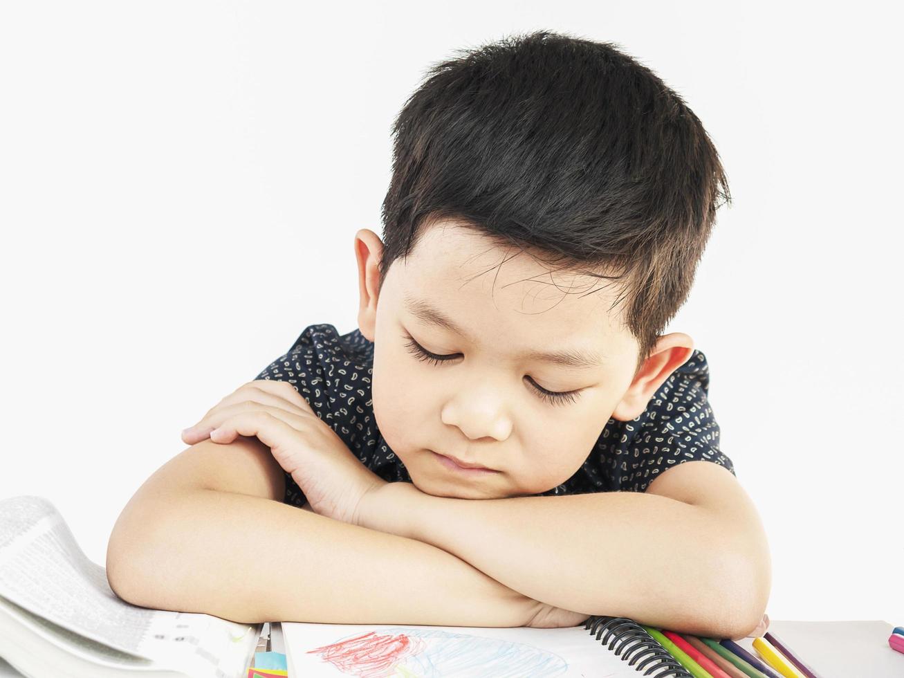 niño asiático está durmiendo mientras lee un libro grande foto