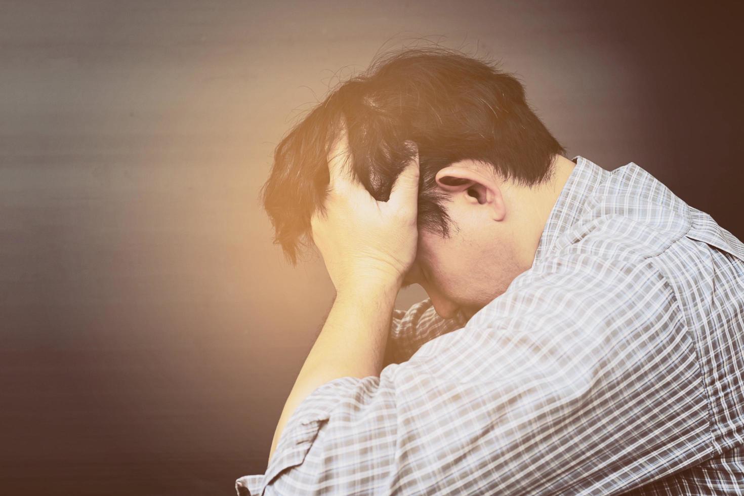 Sad man holding head with hand photo