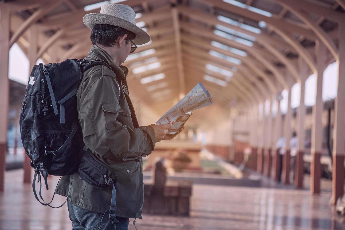 Travel man wait train at platform - people vacation lifestyle activities at train station transportation concept photo