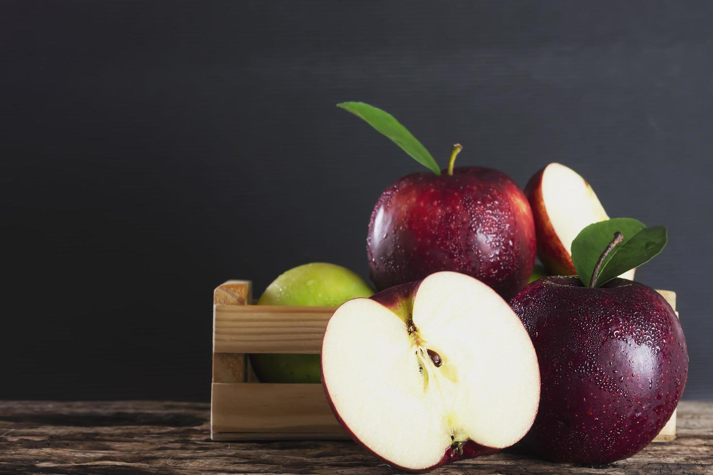 Fresh red green apple and orange over gray black background - fresh fruit background concept photo