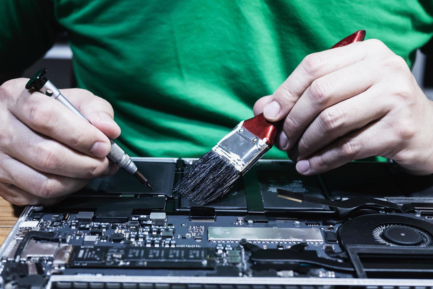 Man fixing laptop computer - technology computer reparing concept photo