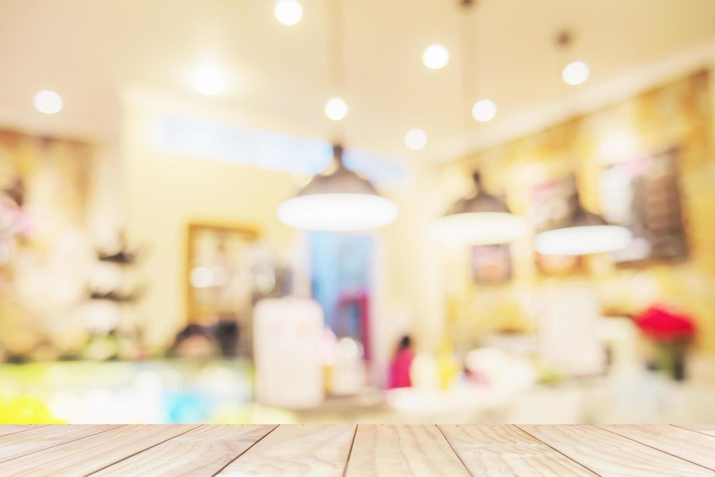 White wooden table over blurred photo of beautiful coffee shop for background use