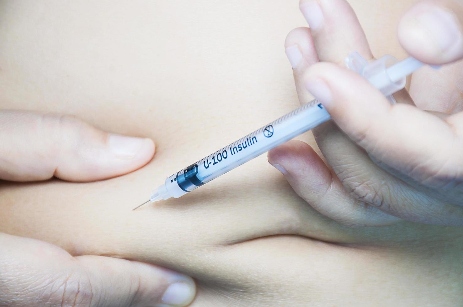 A lady is injecting insulin into her stomach. photo