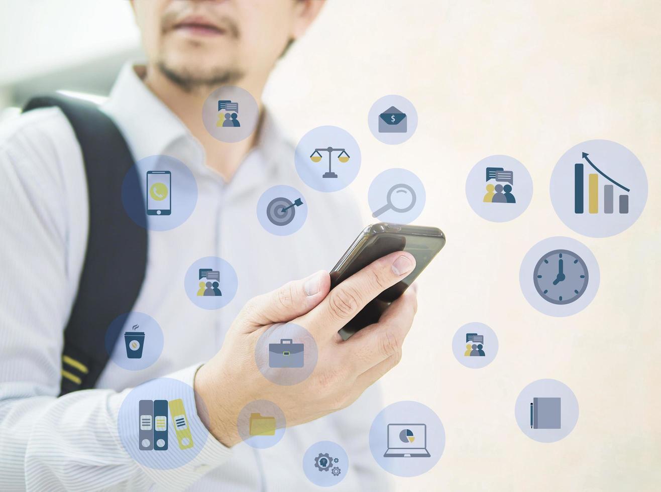 Business traveler using mobile phone during his journey at airport terminal with business icons overlay photo