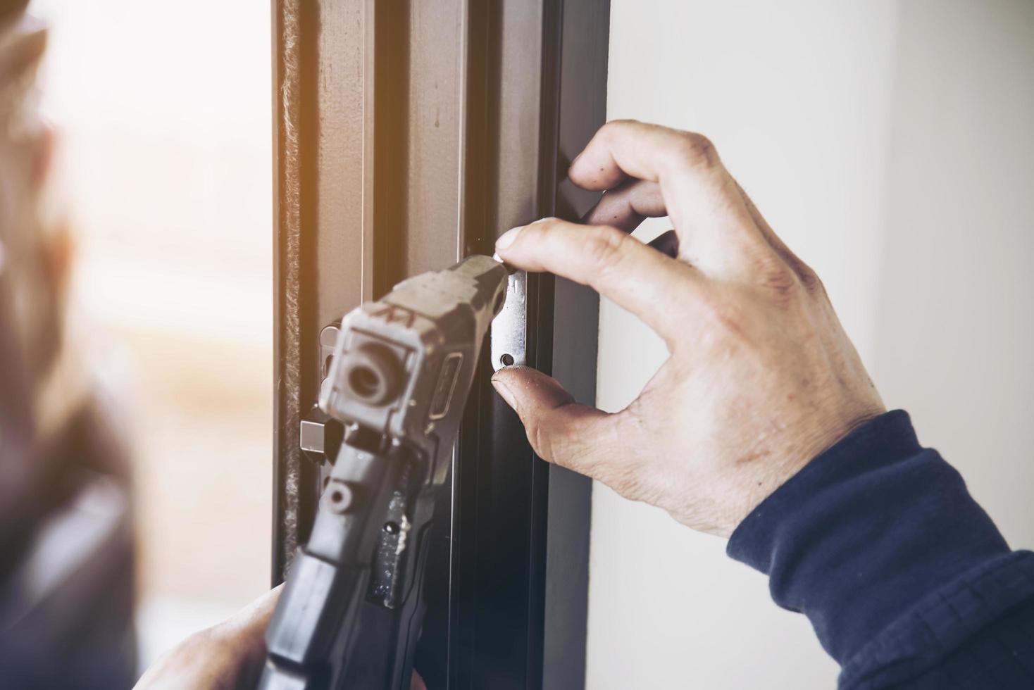 Man doing aluminum frame with glasses and wire screen door and window installation work in construction site photo