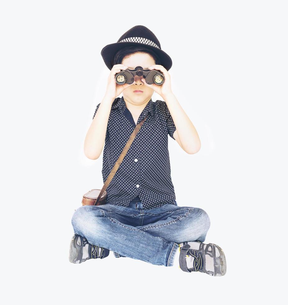 Vintage photo of 7 years old Asian traveler boy is sitting and using binoculars