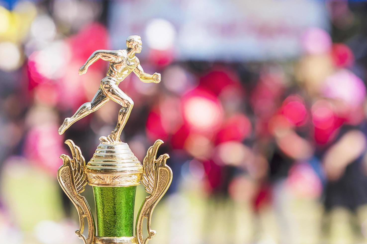 Sport trophy over blur crowded people in school sport day festival photo