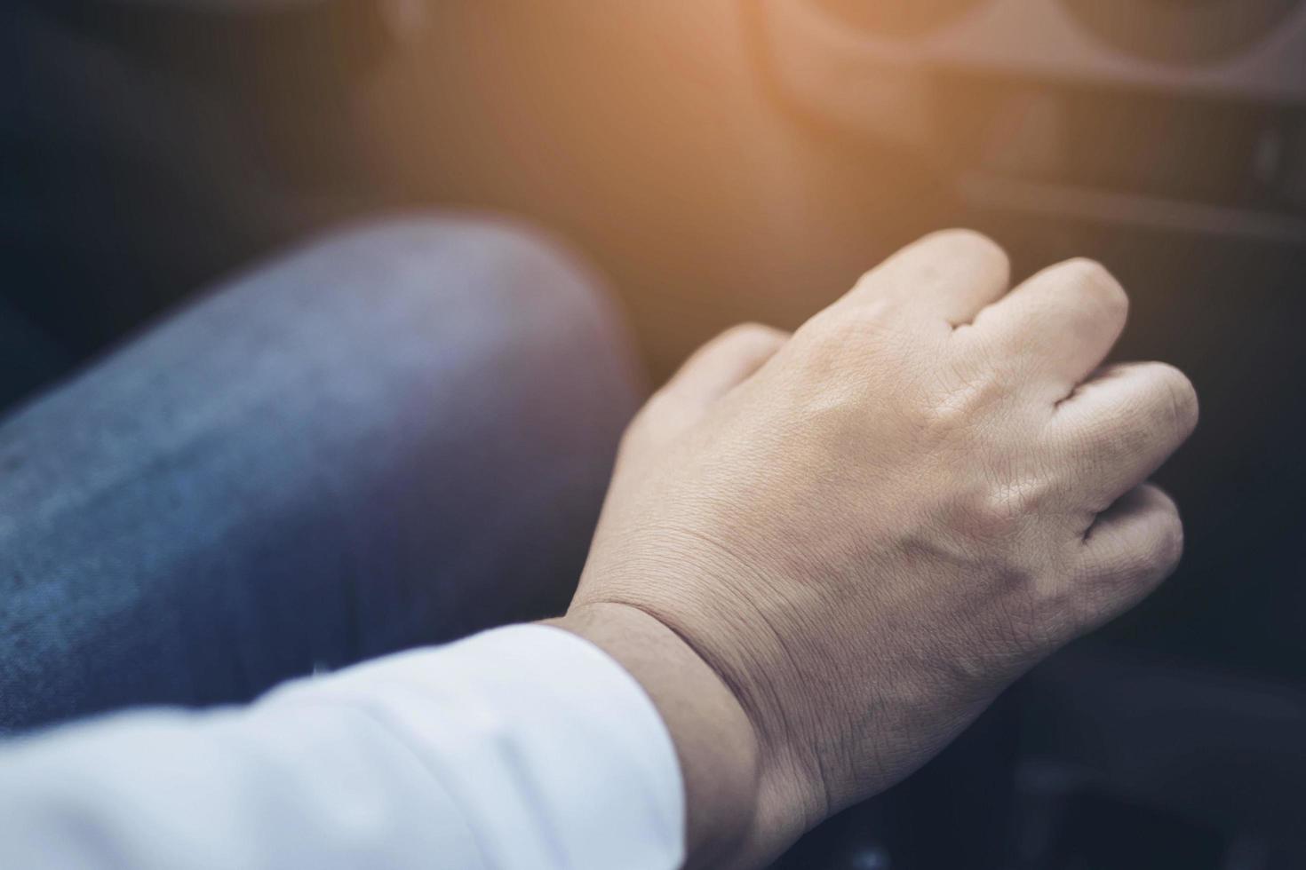 Man driving car while holding automatic gear shift control photo