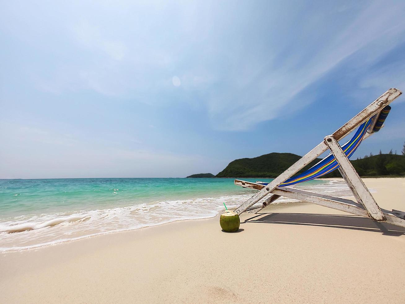 Relax beach chair with fresh coconut on clean sand beach with blue sea and clear sky - sea nature background relax concept photo